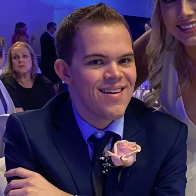 Landon Hughes smiling, wearing a navy suit
